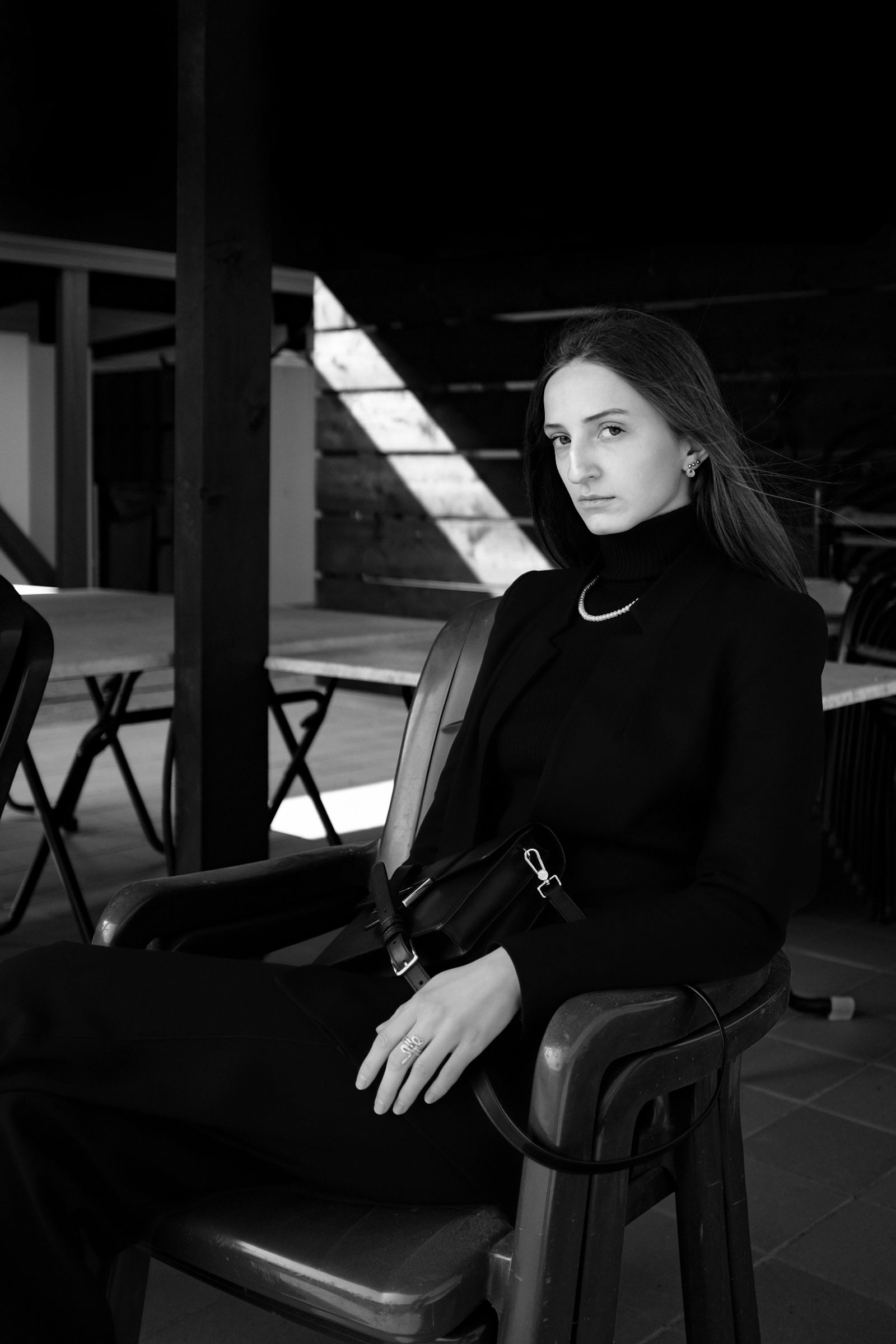 Sitzporträt einer eleganten Frau mit schwarzem Blazer und Rollkragenpullover