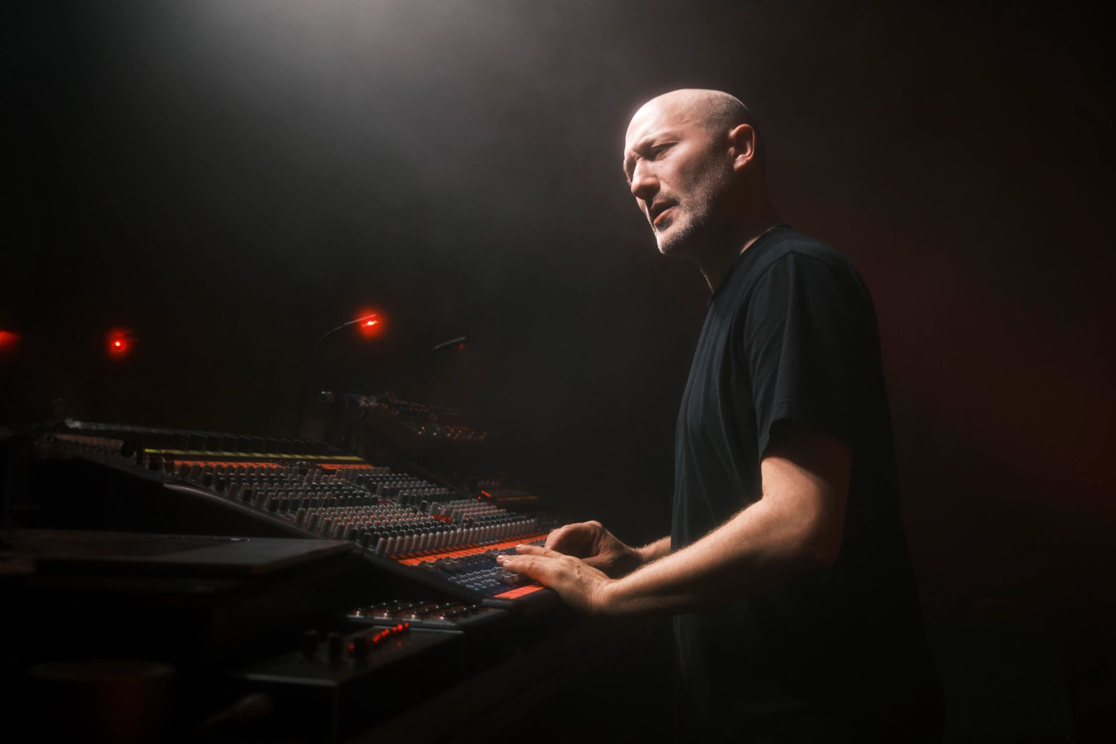 Paul Kalkbrenner steht auf der Bühne und dreht am Mischpult 
