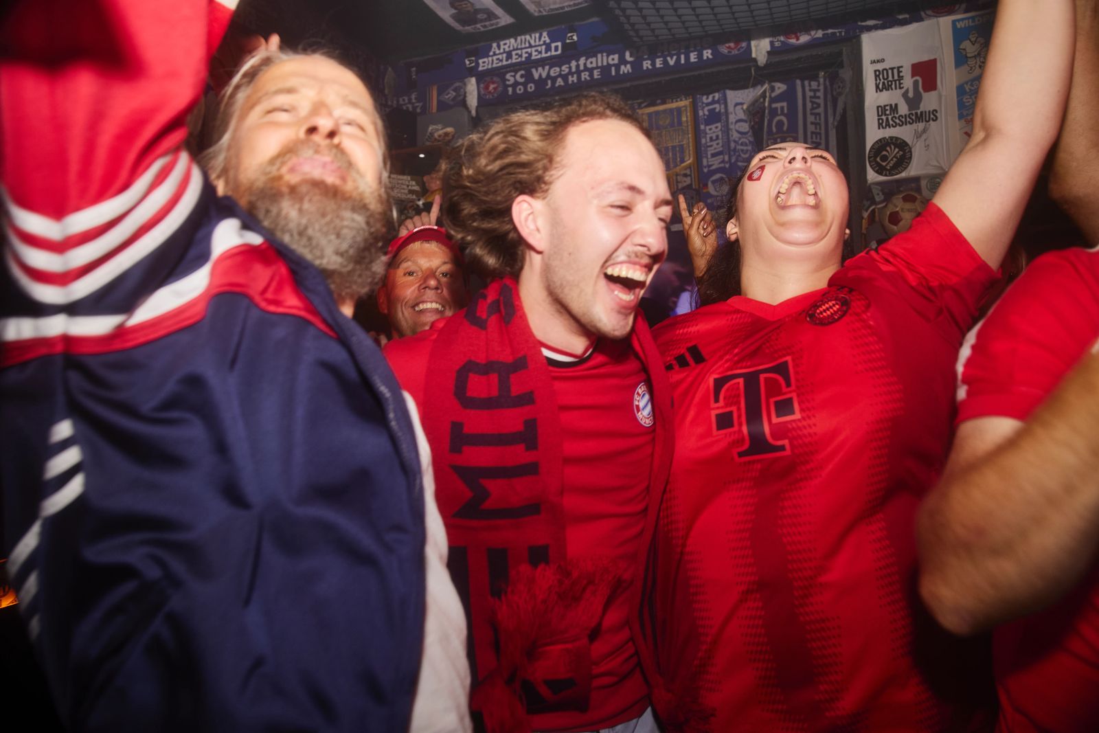 Fußballfans feiern ausgelassen in einer urigen Fankneipel