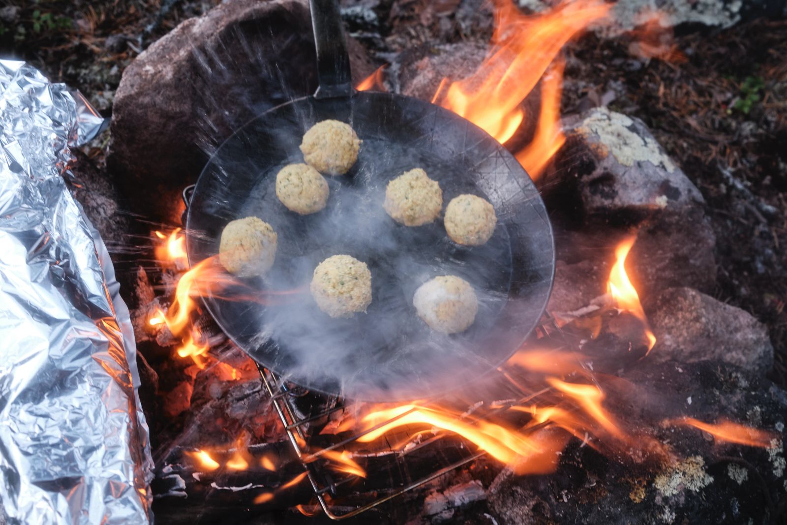 Falafel braten in einer Pfanne über offenem Feuer im Outdoor-Camp.