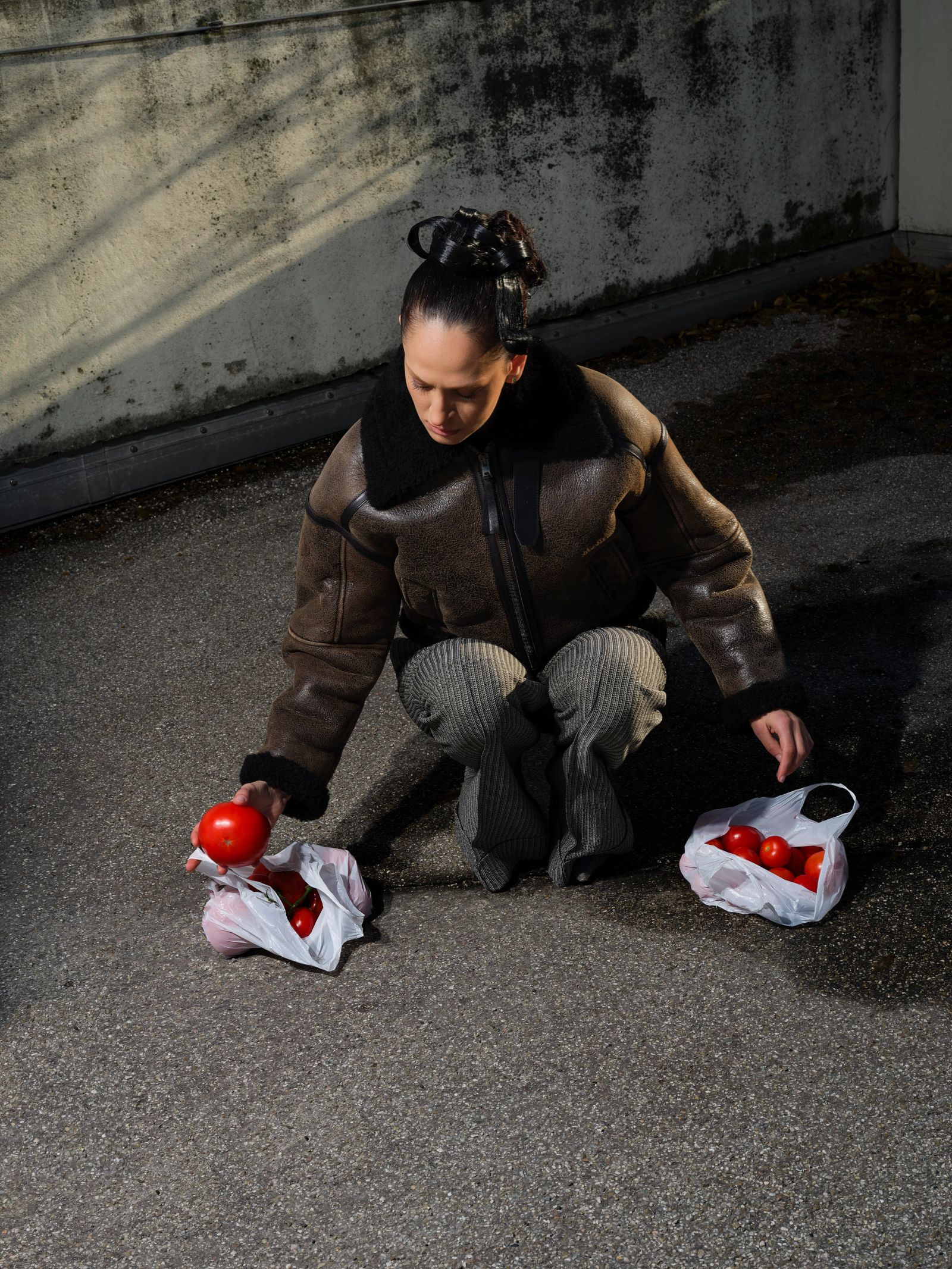 Frau sammelt Tomaten auf Asphalt, Fashion Shoot