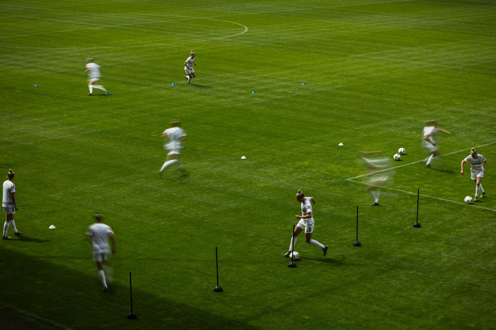Künstlerische Langzeitbelichtung einer Trainingseinheit der FC Bayern Frauen auf dem Campus, mit dynamischer Bewegungsunschärfe der Spielerinnen, fotografiert von Karl Scholten.