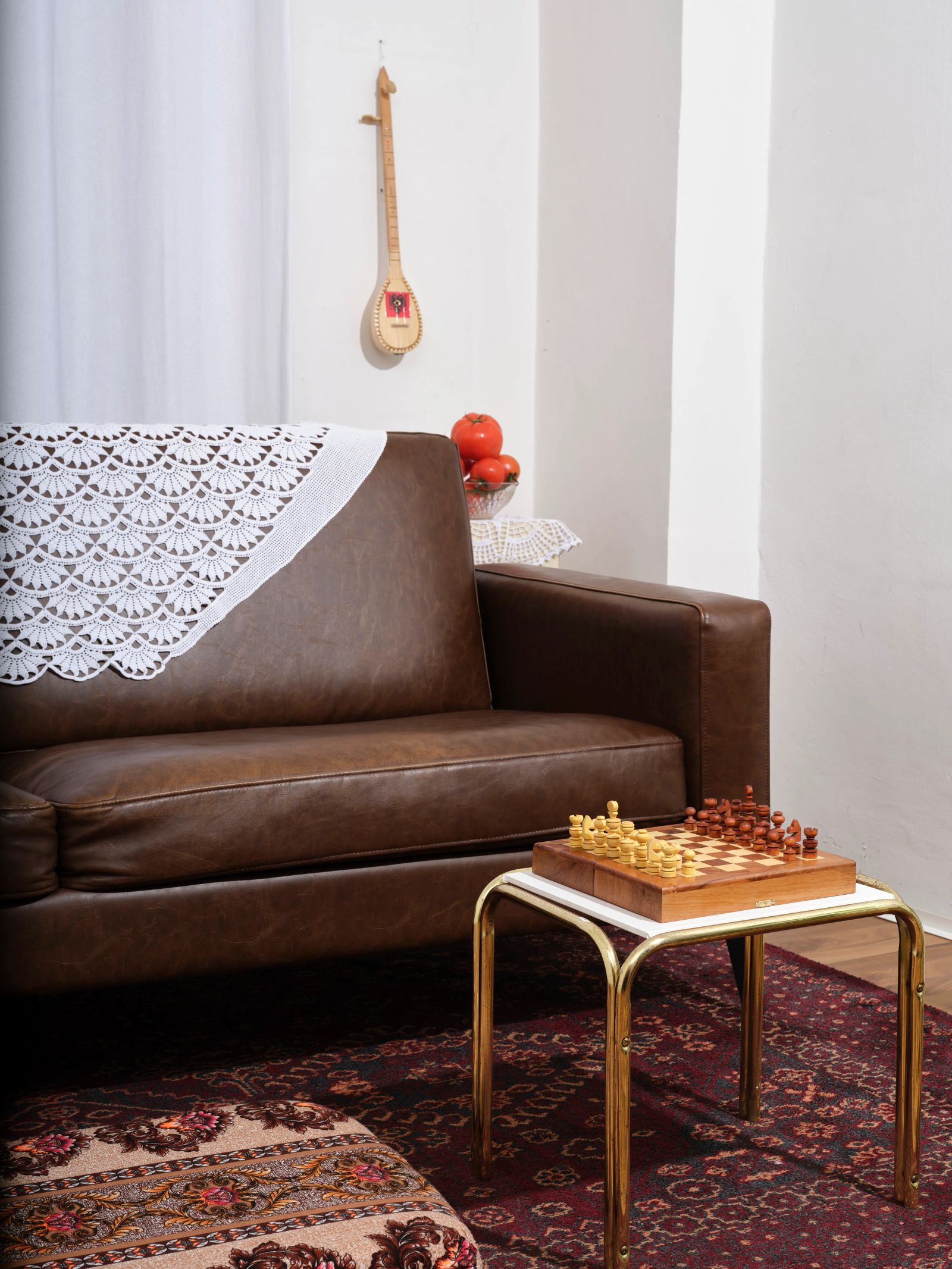 Stillleben mit Ledersofa, Schachbrett und Zupfinstrument, Editorial-Stil