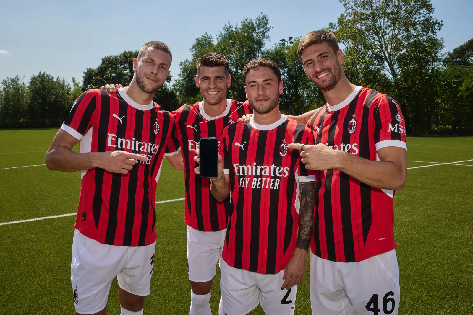 Strahinja Pavlović, Álvaro Morata, Davide Calabria und Matteo Gabbia posieren im AC-Mailand-Trikot auf dem Rasen