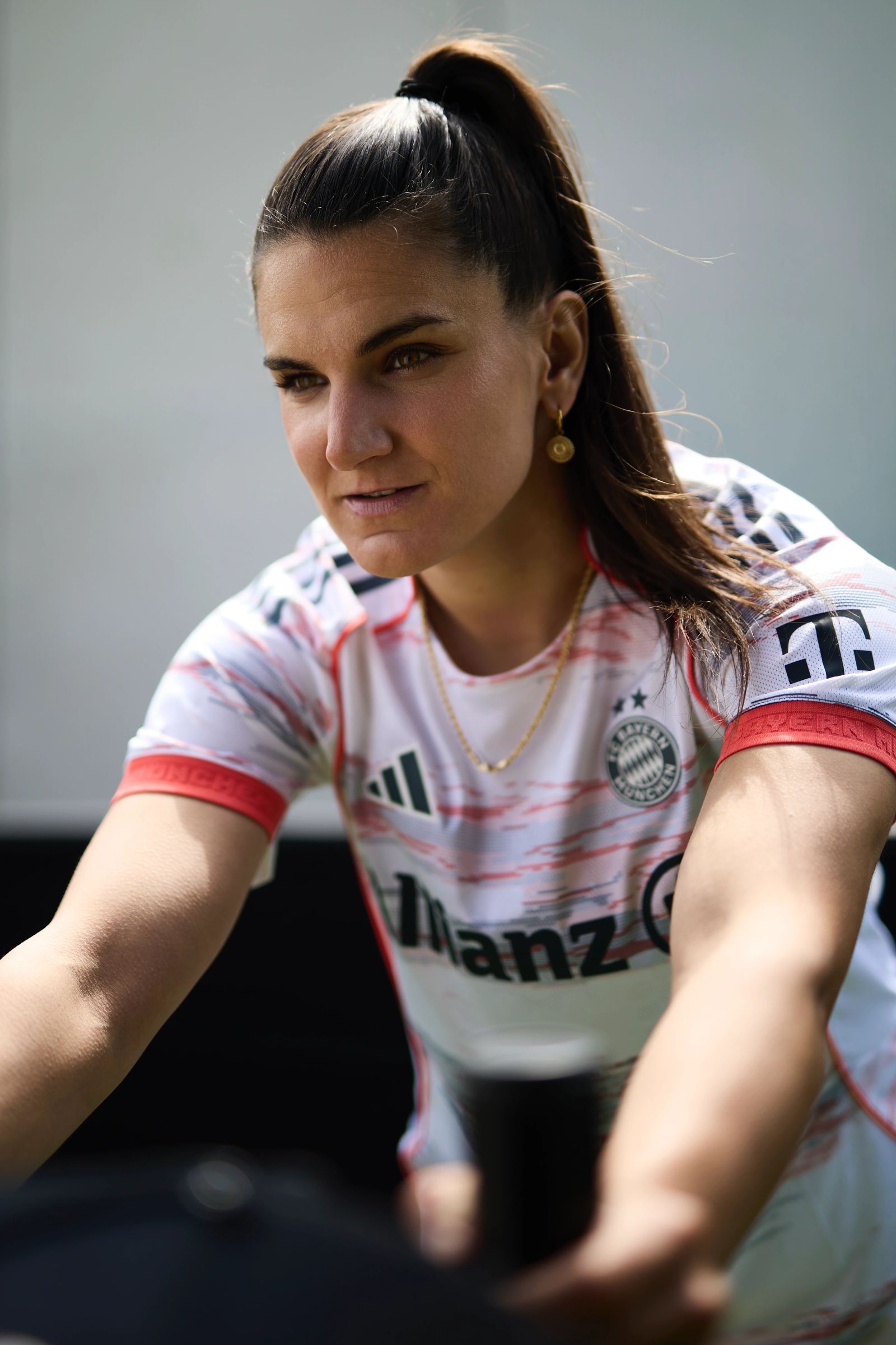 ntensives Close-up-Porträt von Jovana Damnjanović im weißen FC Bayern Trikot mit fokussiertem Blick, fotografiert von Karl Scholten.