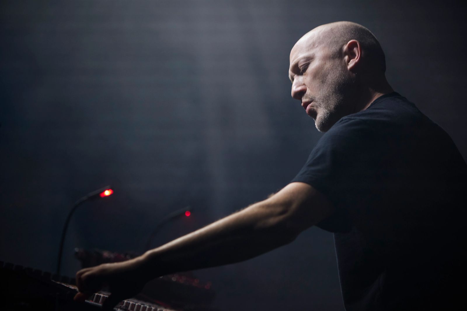 Paul Kalkbrenner steht auf der Bühne und dreht am Mischpult 