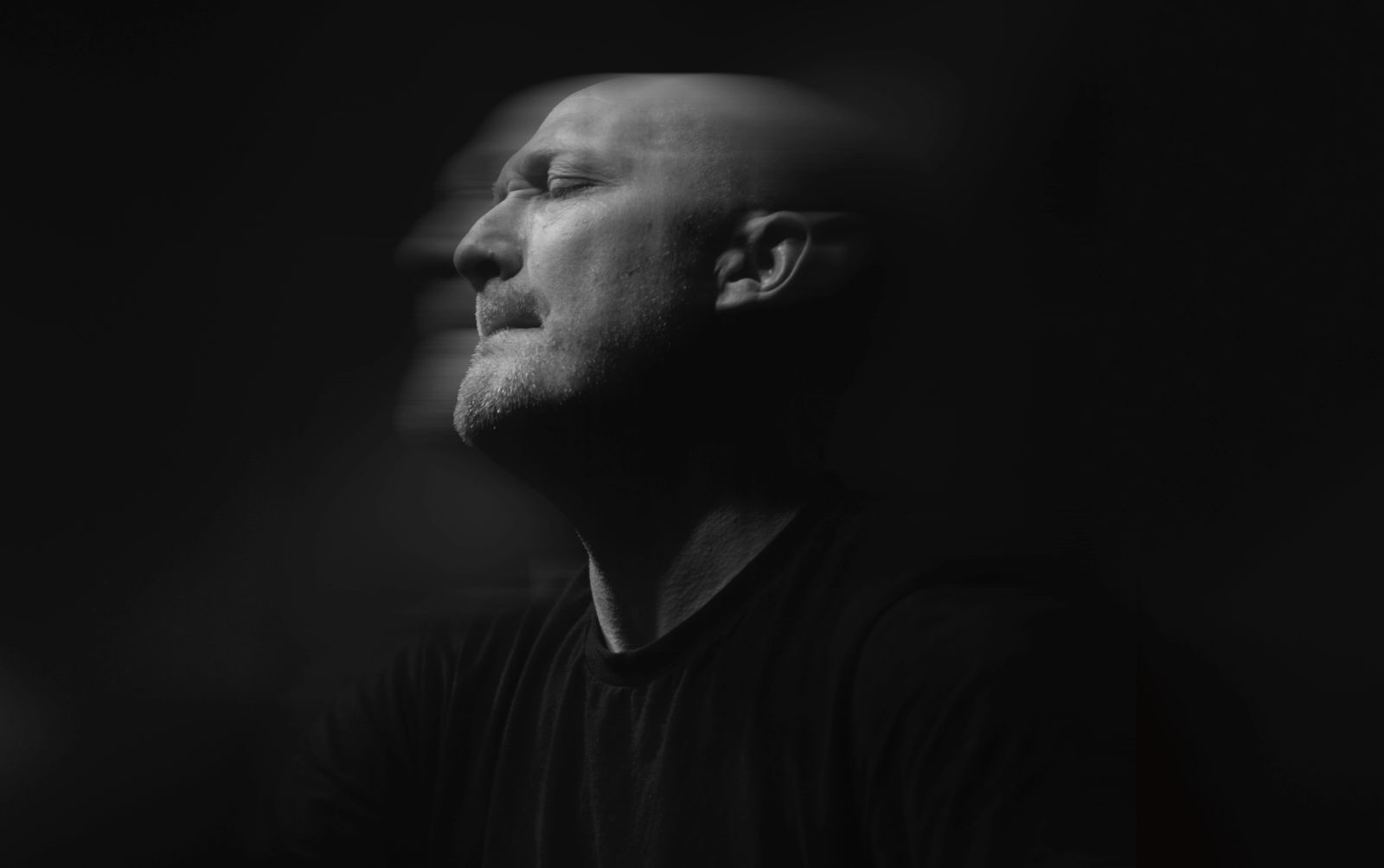 Bewegungsunscharfes schwarzweiß Potrait von Paul Kalkbrenner auf der Bühne