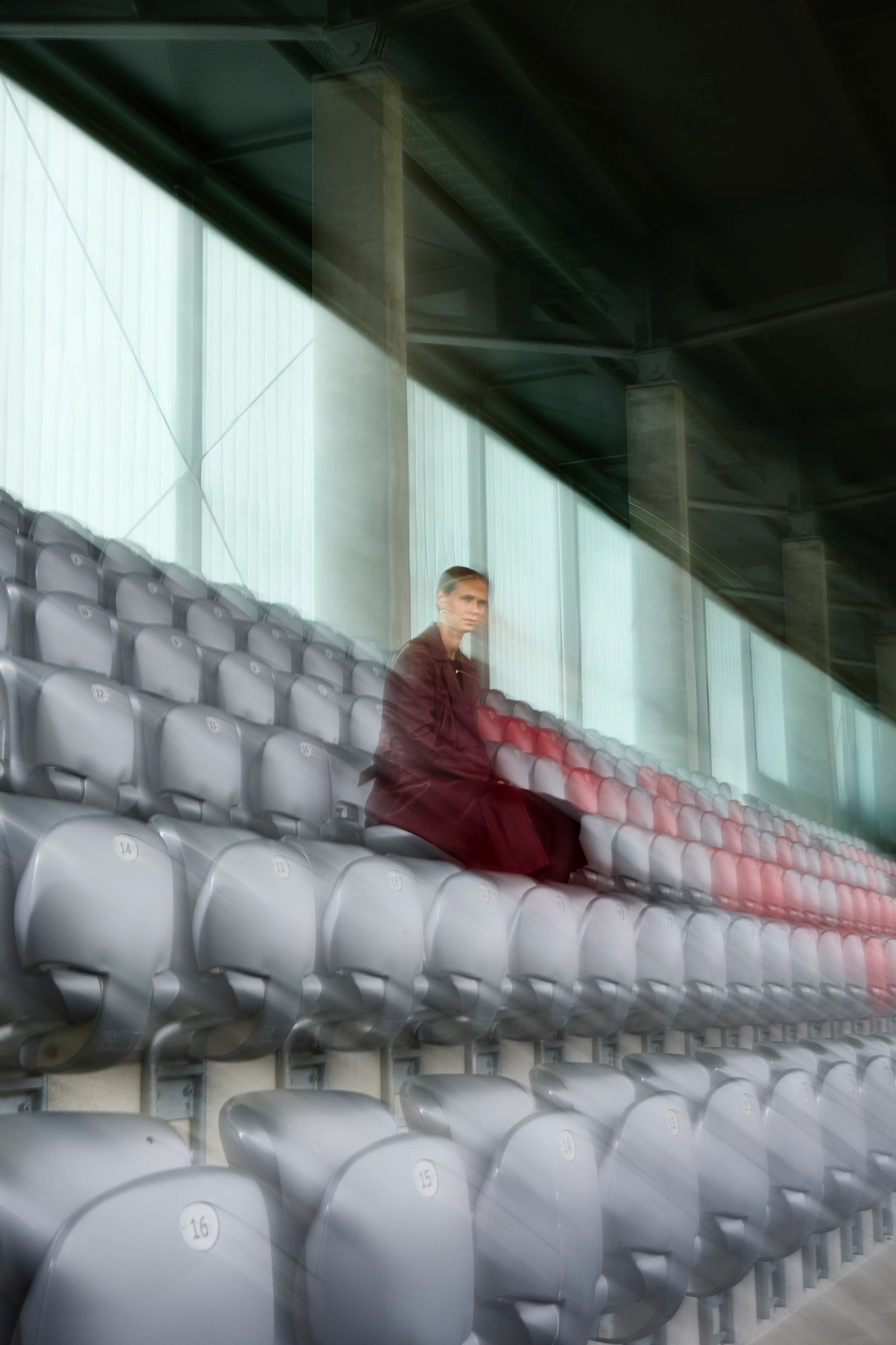 Kreative Aufnahme von Klara Bühl auf einer leeren Stadiontribüne mit einem künstlerischen Double-Exposure-Effekt, fotografiert von Karl Scholten