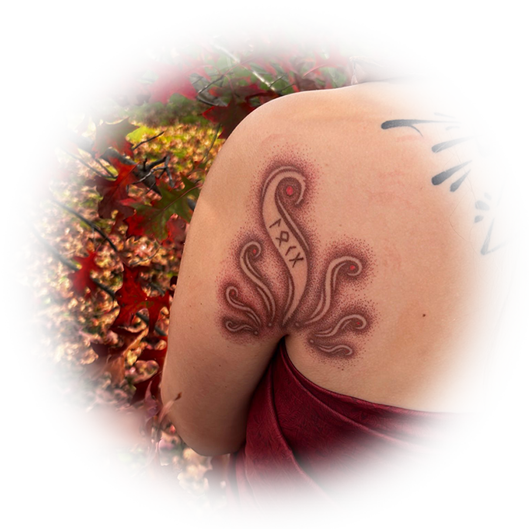 Hand-poked tattoo of a flowing ornamental design on a shoulder