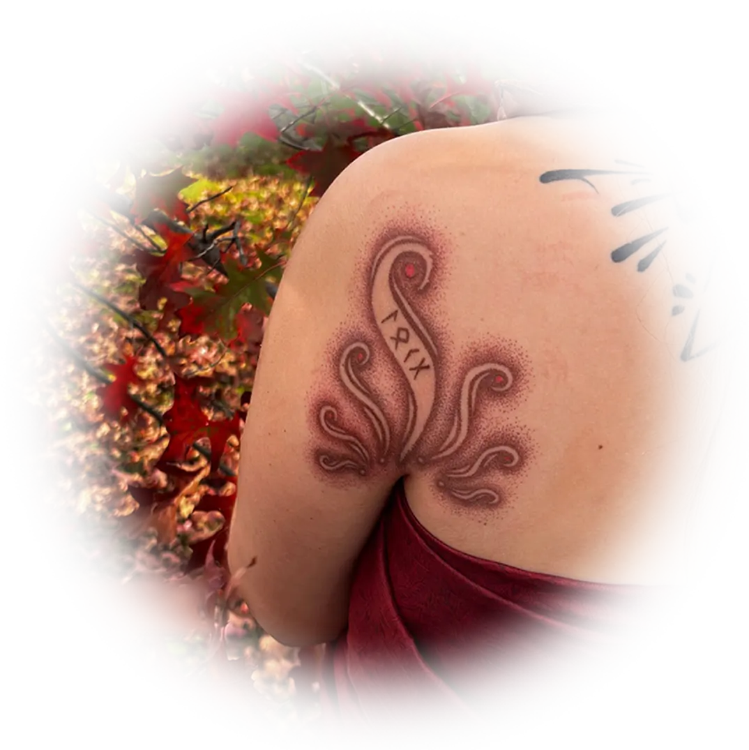 Hand-poked tattoo of a flowing ornamental design on a shoulder