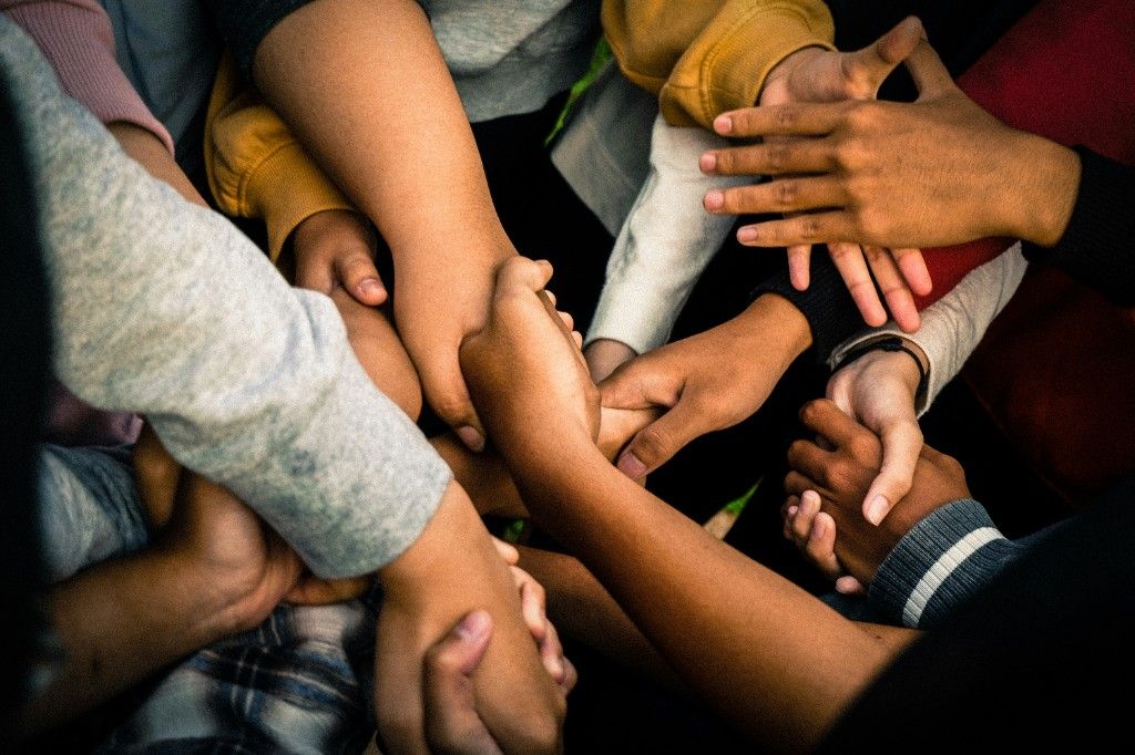 Diverse hands joined together in a circle viewed from above