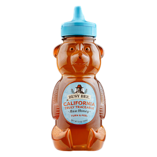 Front of 12 oz California Busy Bee Raw Honey bear bottle with blue label and blue lid