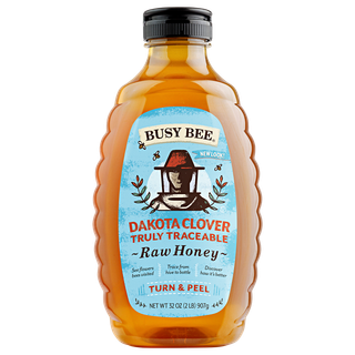 Front of 32 oz Dakota Clover Busy Bee Raw Honey Bottle with blue label
