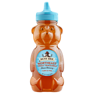 Front of 12 oz Northeast Busy Bee Raw Honey bear bottle with blue label and blue lid