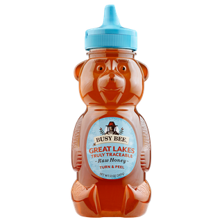Front of 12 oz Great Lakes Busy Bee Raw Honey bear bottle with blue label and blue lid