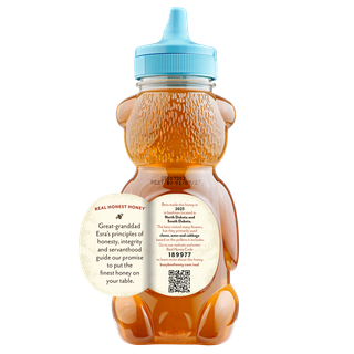 Back of 12 oz Midwest Busy Bee Raw Honey bear bottle with label peeled away to share this honey's story
