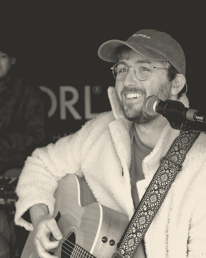 Etienne an der Akustikgitarre am Mikrofon