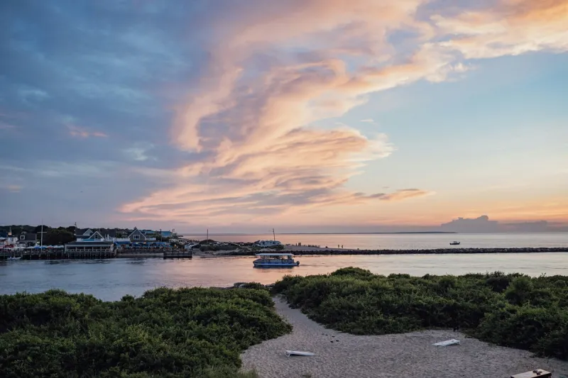 Montauk harbor at sunset with dune path and beach grass