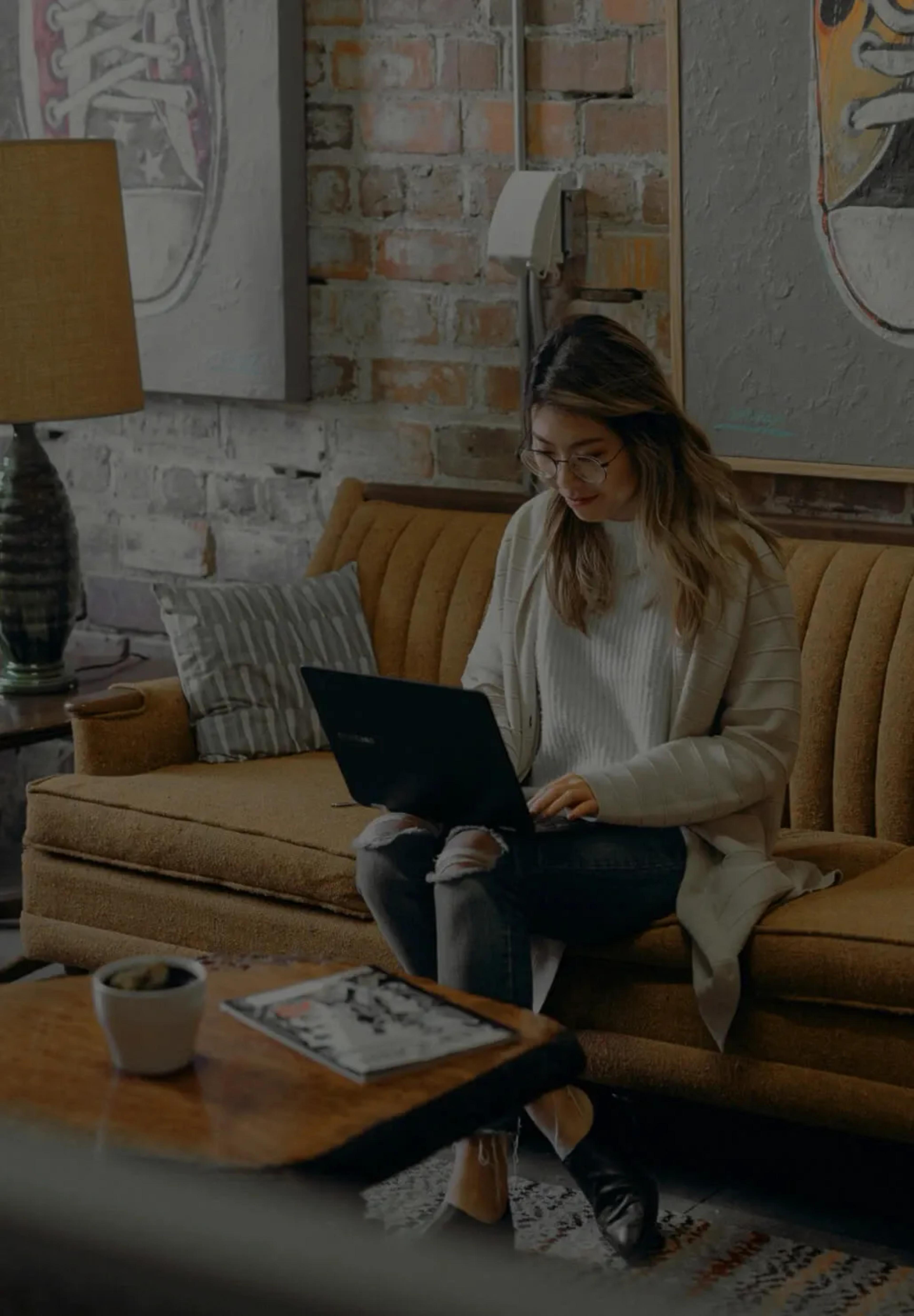 Woman sitting on a couch using a laptop
