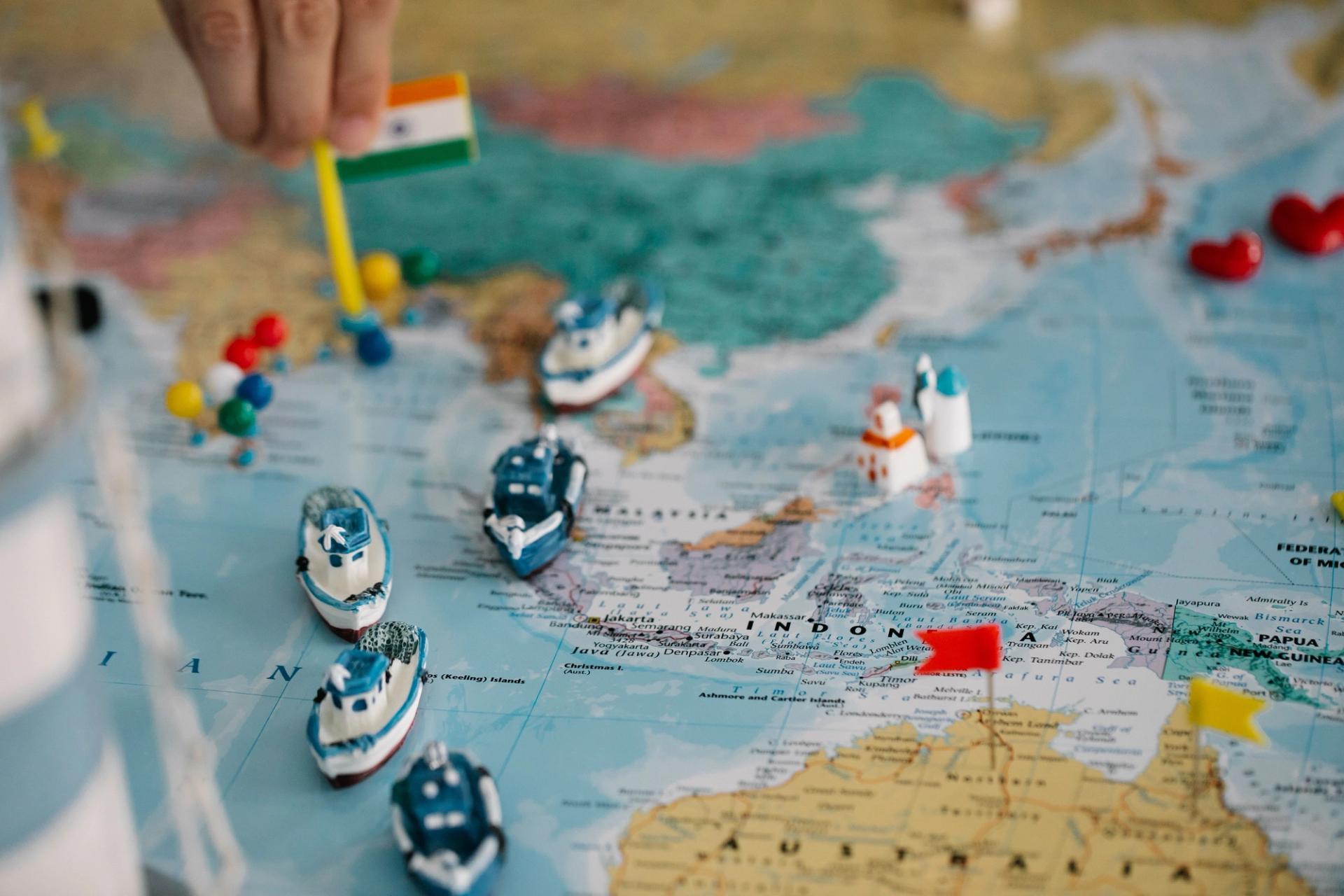 Map of Southeast Asia with an Indian flag pin and miniature cargo ships marking multiregional manufacturing routes across China, India, and Indonesia
