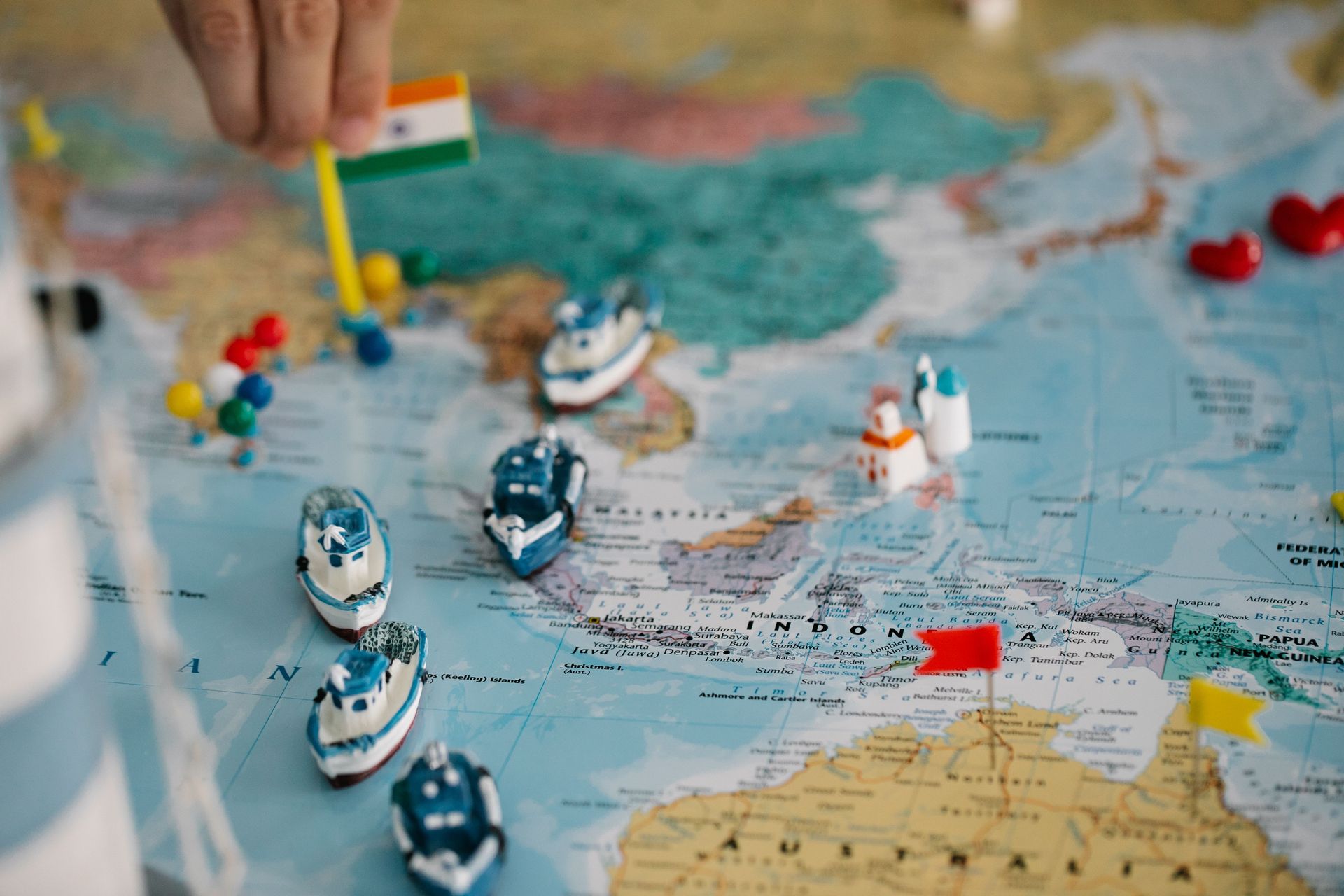 Map of Southeast Asia with an Indian flag pin and miniature cargo ships marking multiregional manufacturing routes across China, India, and Indonesia