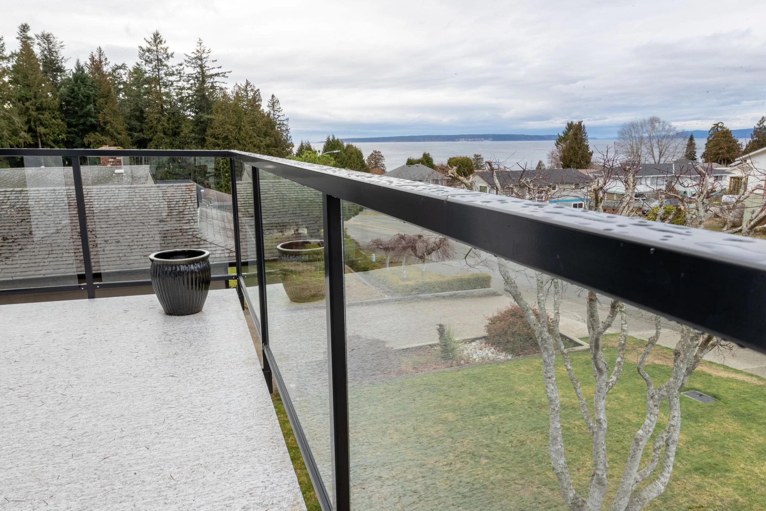 Glass deck railing installation showing tempered glass panels and aluminum posts on residential deck and stairs