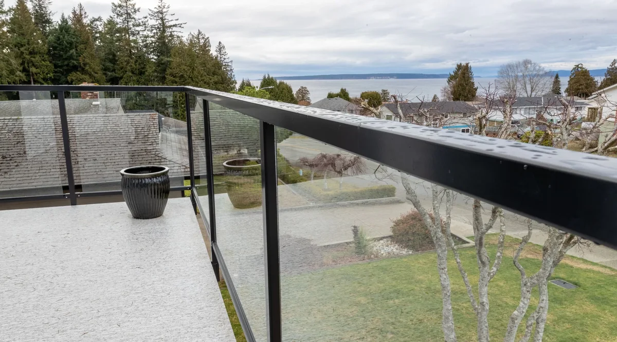 Glass deck railing installation showing tempered glass panels and aluminum posts on residential deck and stairs