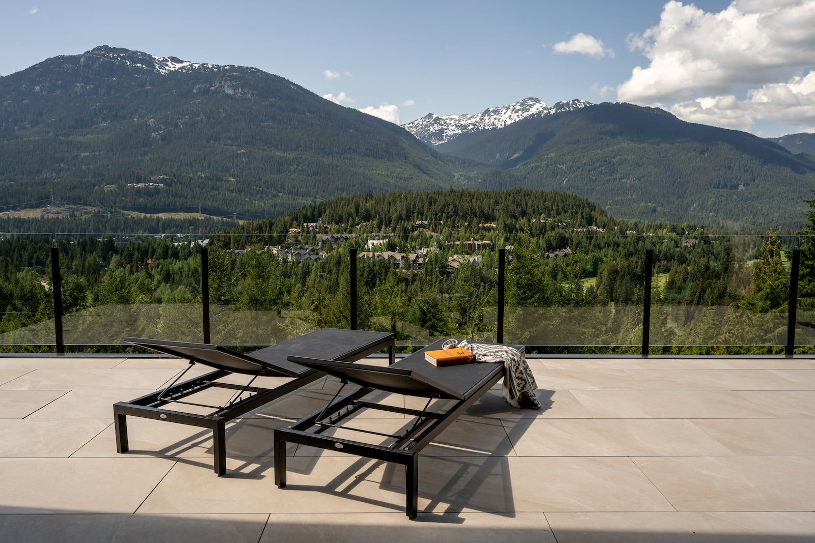 Clear tempered glass railing panels on a luxury Whistler BC deck with mountain views showing maximum transparency