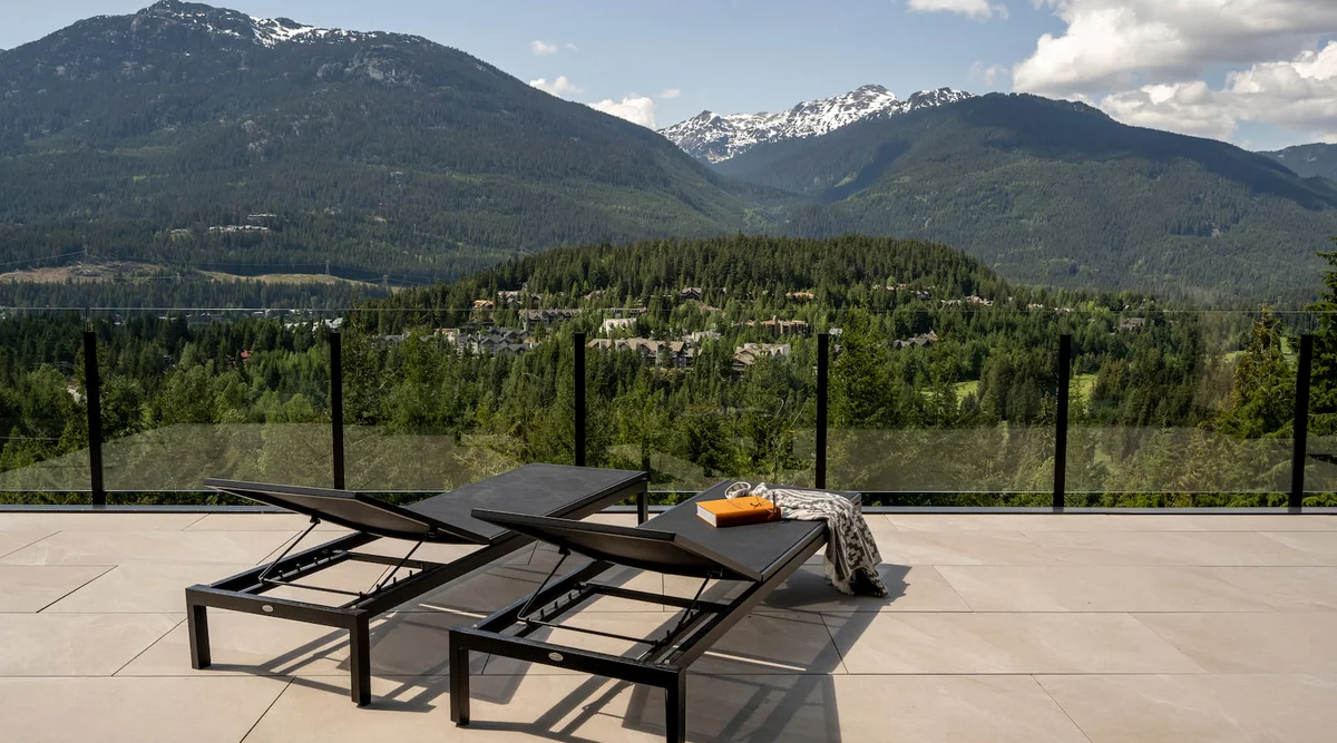 Clear tempered glass railing panels on a luxury Whistler BC deck with mountain views showing maximum transparency