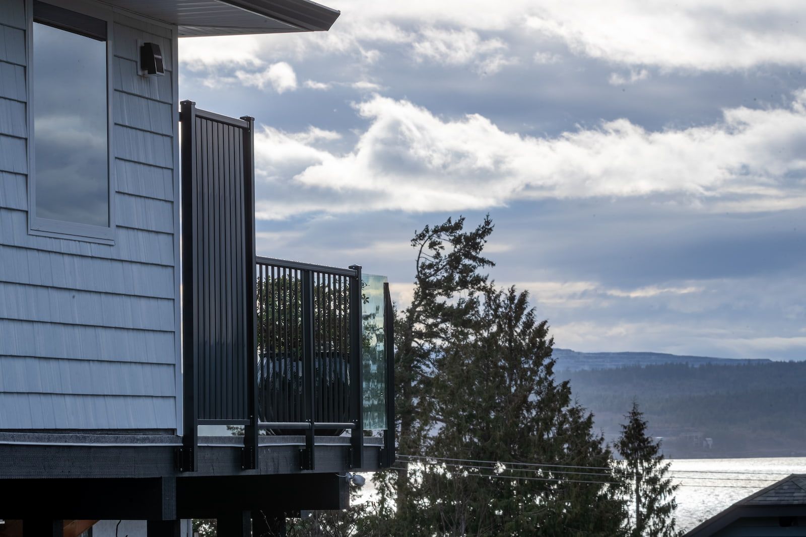 Fascia mount black aluminum picket and glass privacy panel railing on a coastal home in Powell River BC