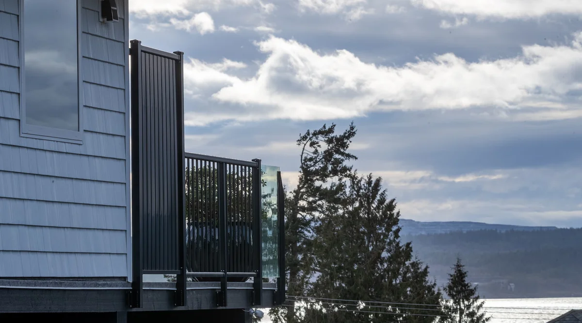 Fascia mount black aluminum picket and glass privacy panel railing on a coastal home in Powell River BC