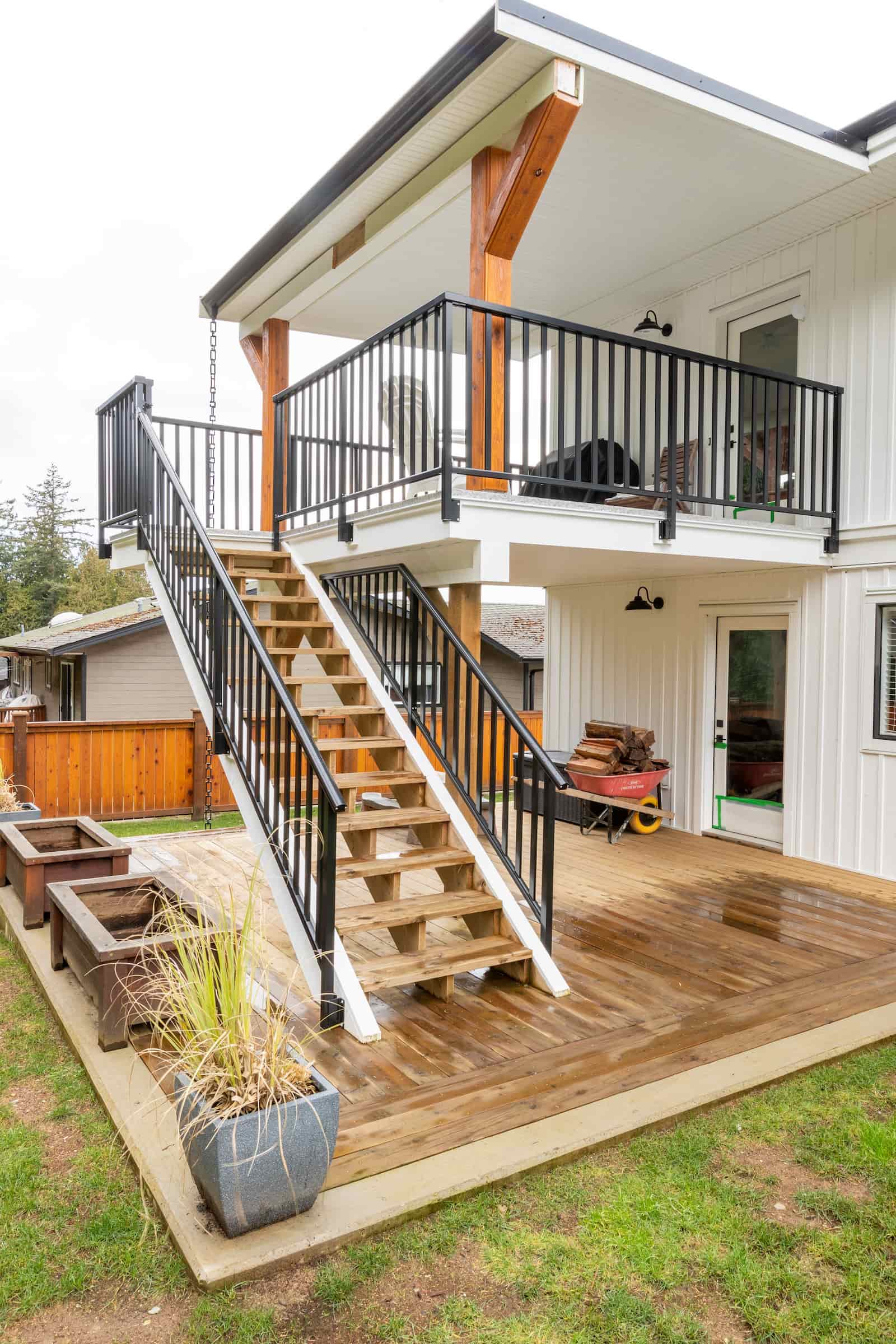 Black aluminum picket railing showing the stair-to-deck transition with colonial top rail on stairs for graspability code compliance in Powell River, BC