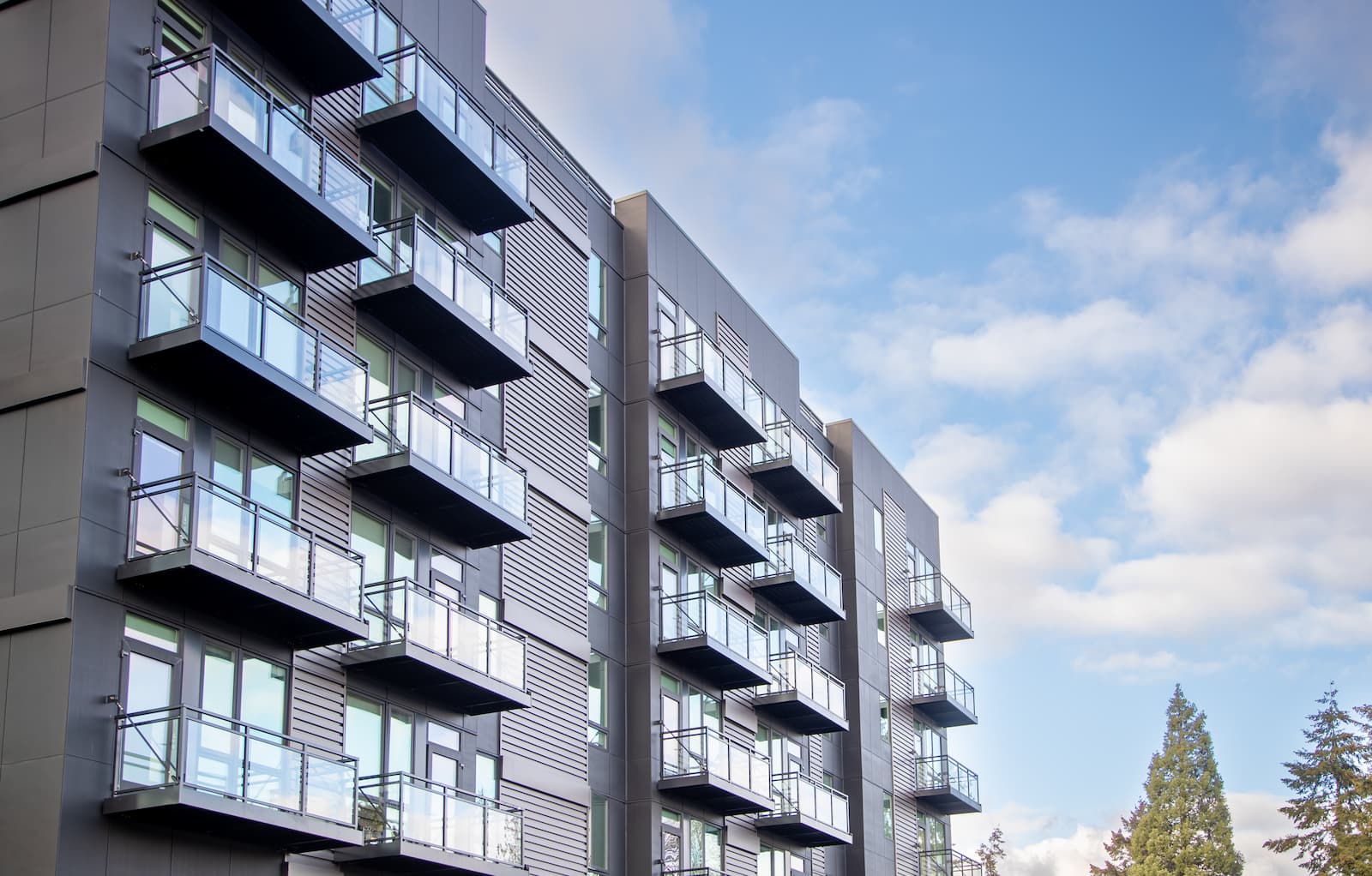 Glass balcony railing with black aluminum frame on a modern multi-family building in the Seattle Washington area