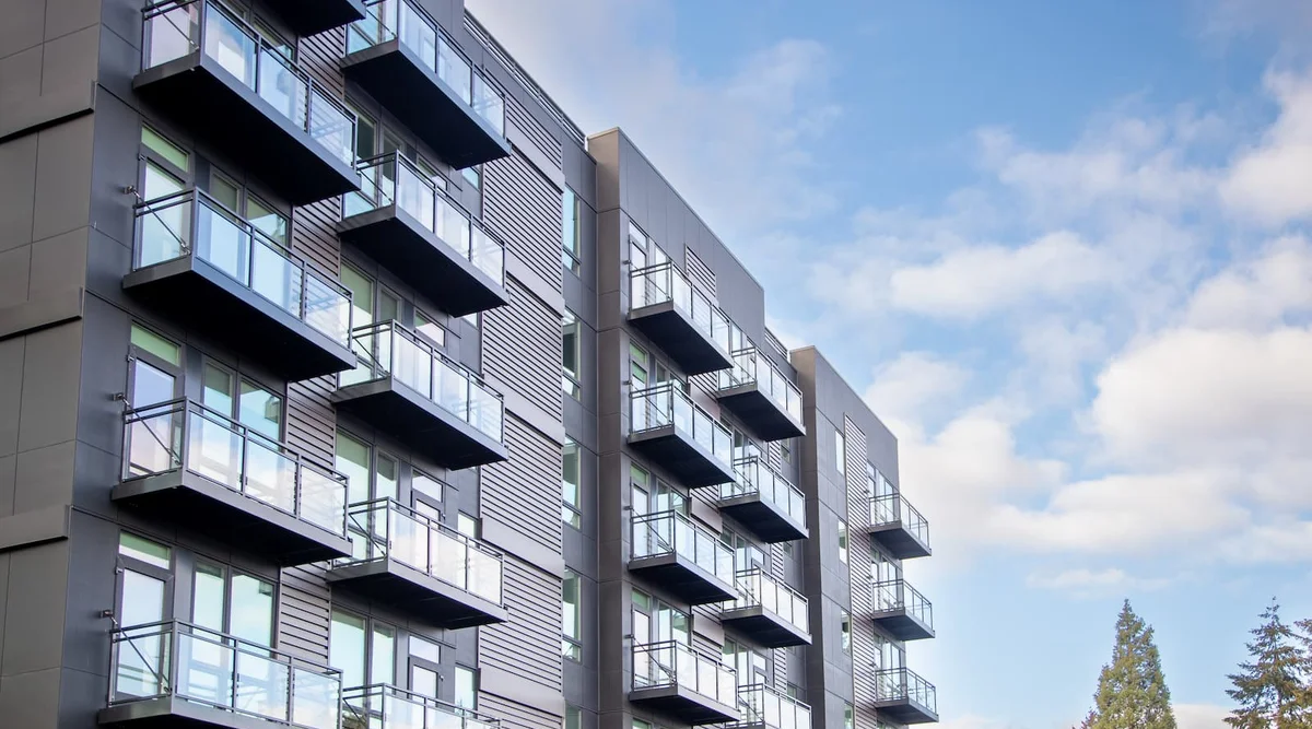 Glass balcony railing with black aluminum frame on a modern multi-family building in the Seattle Washington area