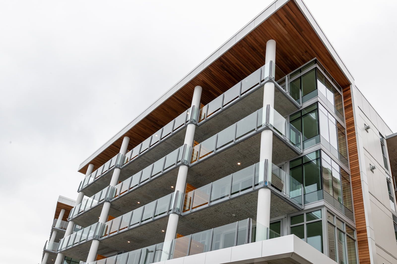 Surface mount infinity topless glass railing on a rooftop common area of a multi-family building in Seattle Washington