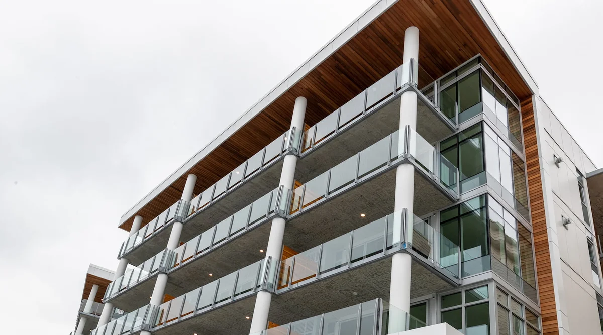 Surface mount infinity topless glass railing on a rooftop common area of a multi-family building in Seattle Washington