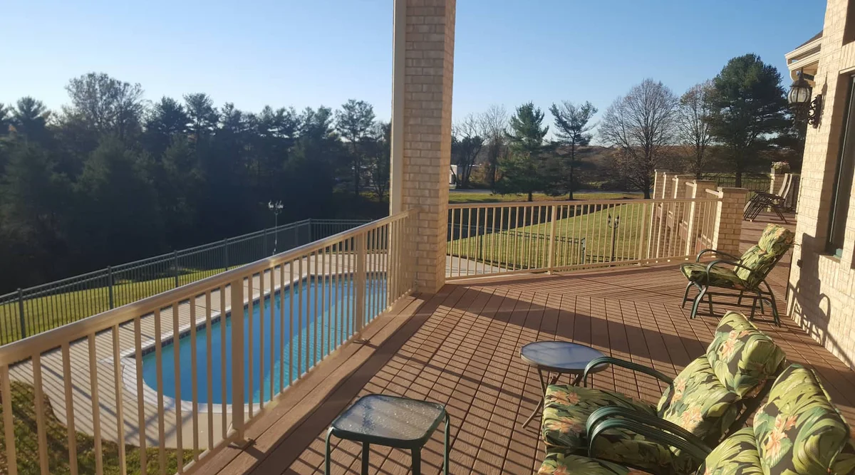 Light ivory powder coated aluminum picket railing around a pool deck in Maryland