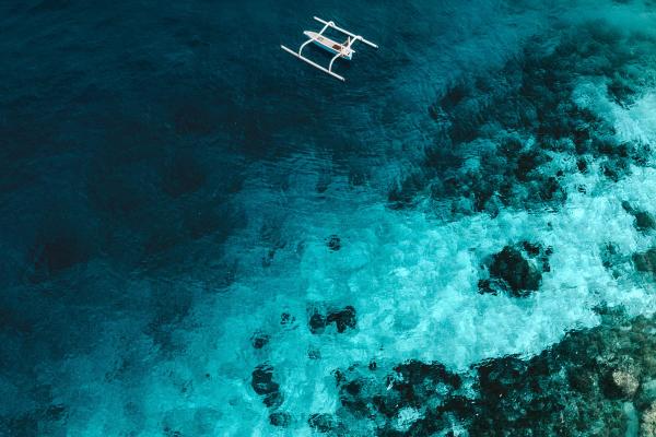 Smiling stewardess in uniform standing confidently inside a luxury yacht.