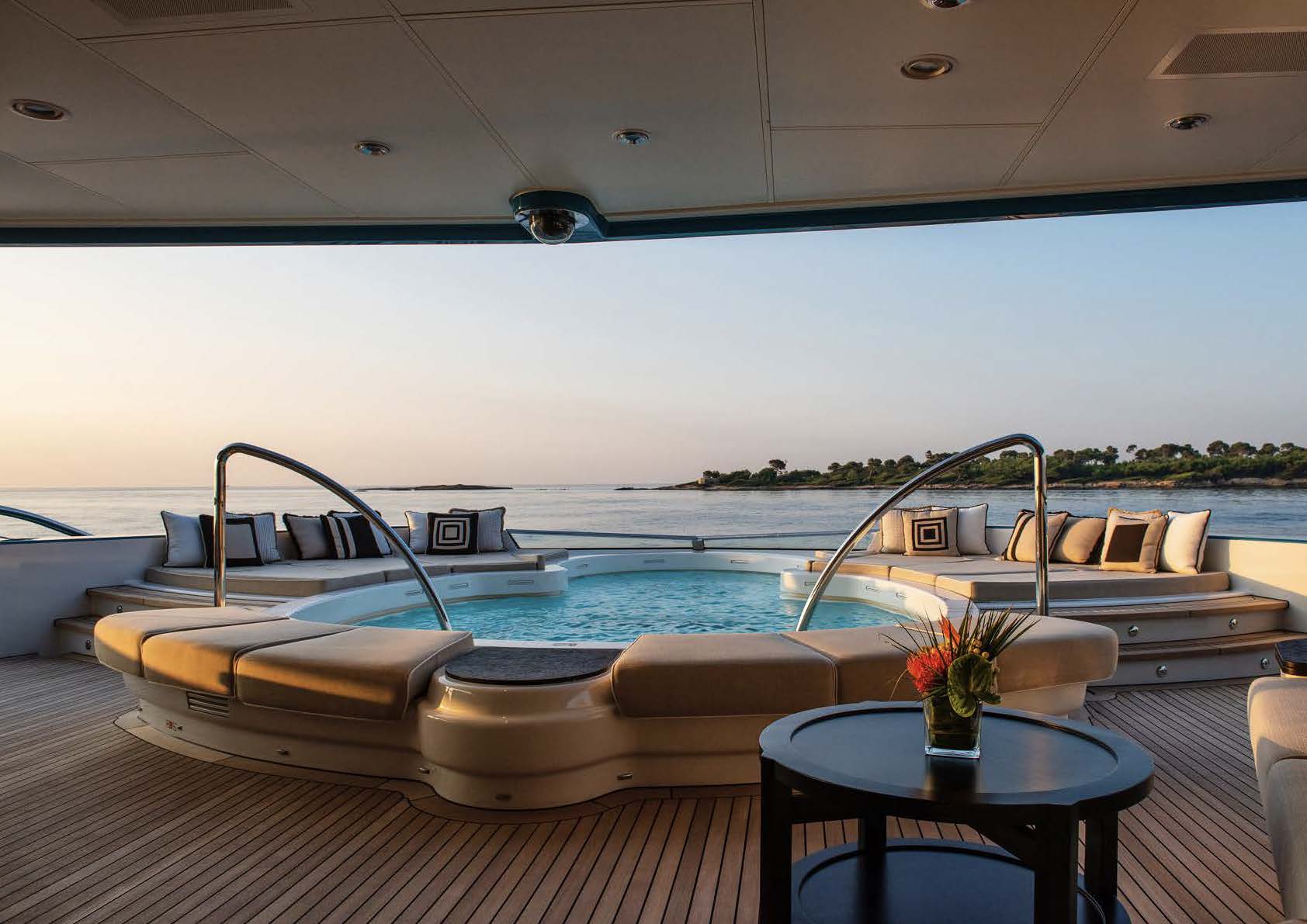 Luxury yacht cruising on calm blue ocean with clear sky.