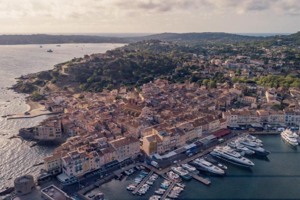Scenic view of a luxury yacht anchored with dramatic coastal cliffs in the background.