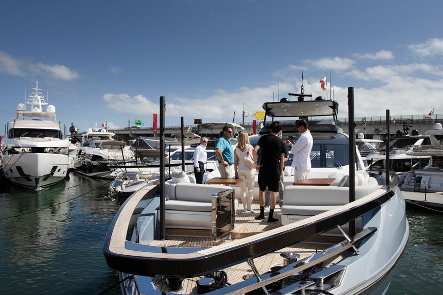 Luxury yacht cruising on calm blue sea under sunny sky.