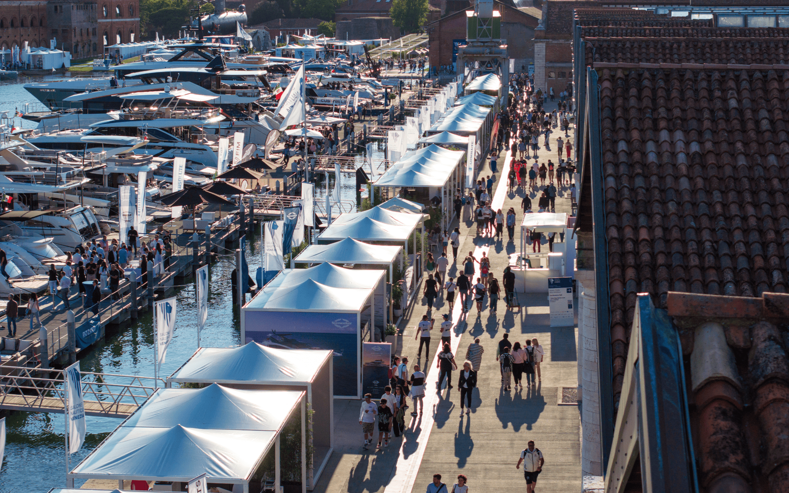 Modern yacht docked at marina under clear blue sky.