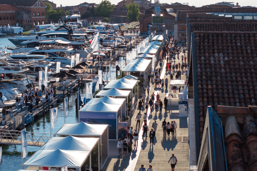 Modern yacht docked at marina under clear blue sky.