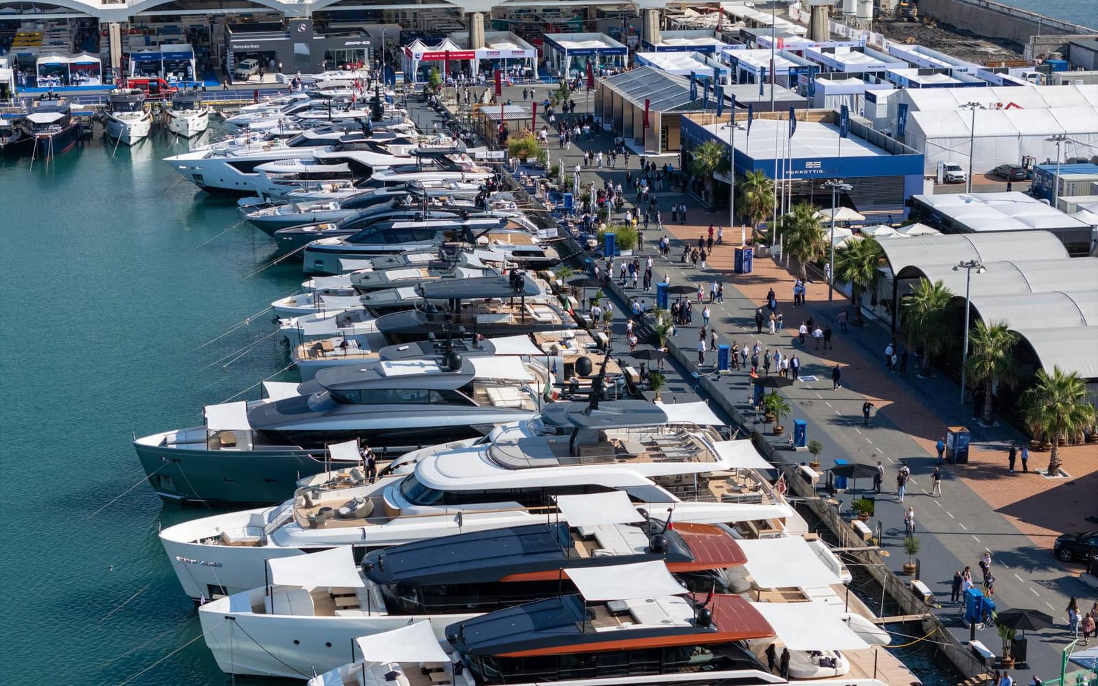 Modern luxury yacht anchored near a scenic coastal town with clear blue skies.
