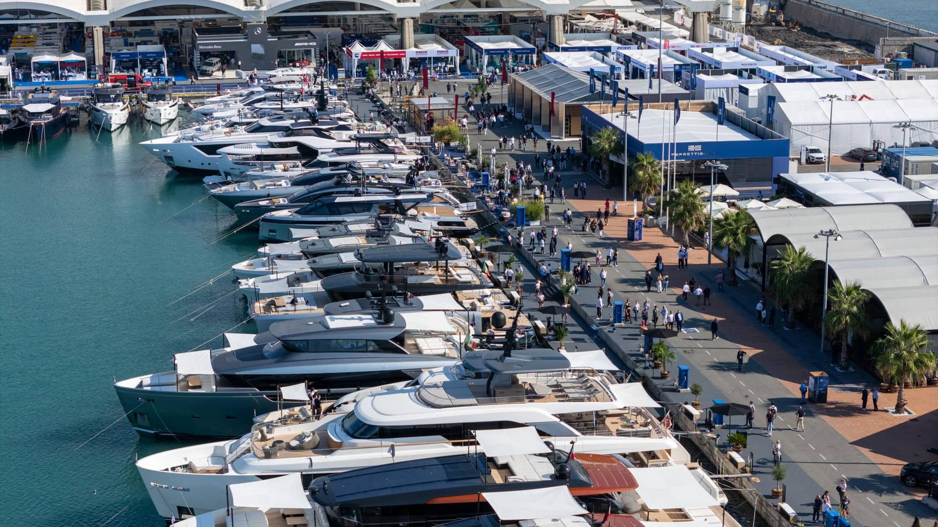 Modern luxury yacht anchored near a scenic coastal town with clear blue skies.