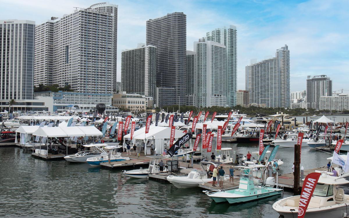 Elegant white yacht docked at marina with clear blue sky.