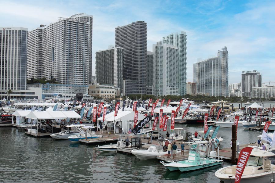 Elegant white yacht docked at marina with clear blue sky.