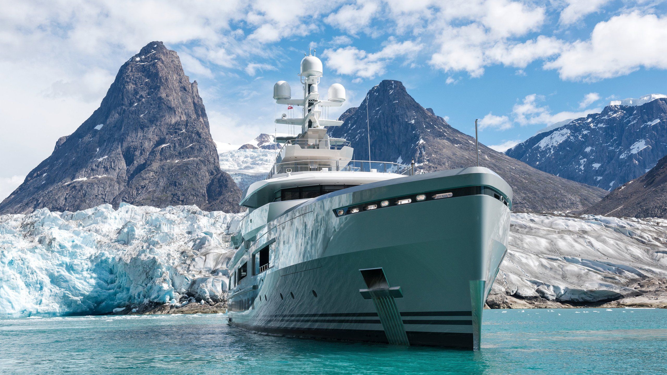 Elegant white yacht docked at marina under clear sky.