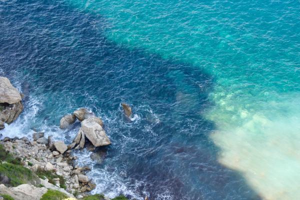 Female crew member preparing drinks at an open-air yacht bar.