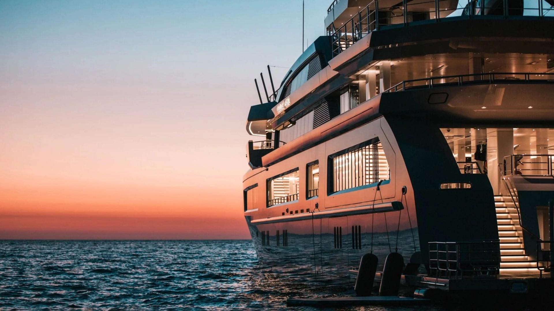 Modern luxury yacht sailing on deep blue ocean with clear sky and calm water.